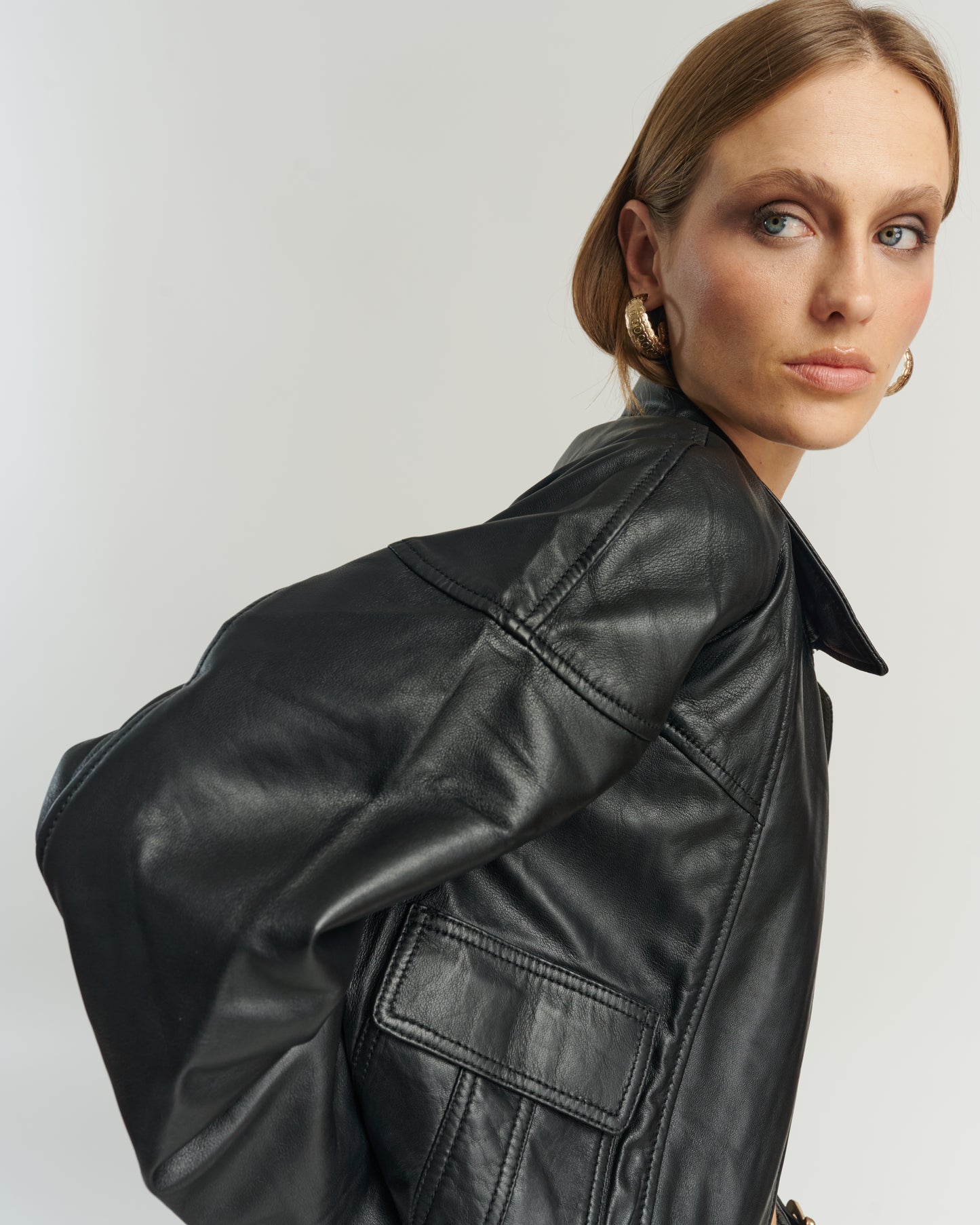 Detalle cremallera y textura bomber cuero ovino negro — calidad y acabados HER Chile