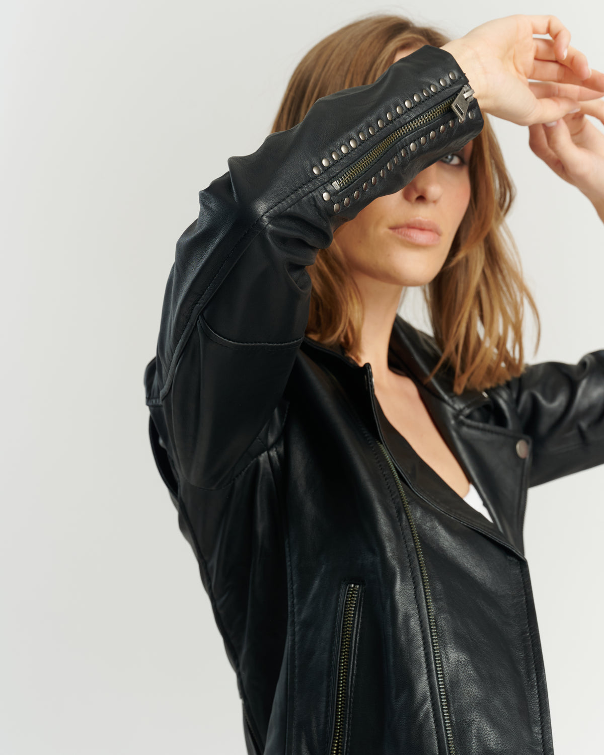 Detalle tachas en manga chaqueta biker negra 100% cuero ovino — sello de diseño HER Chile